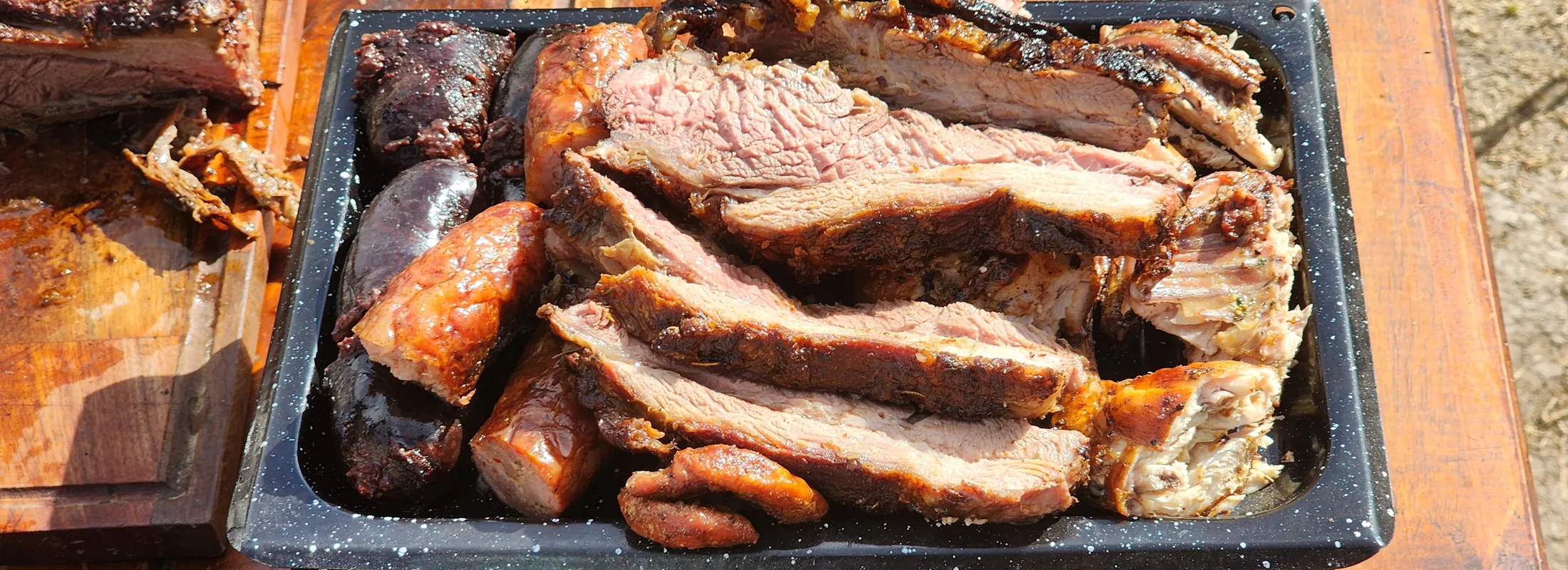 Bandeja con carne cortada, morcilla y chorizo sobre la mesa de madera